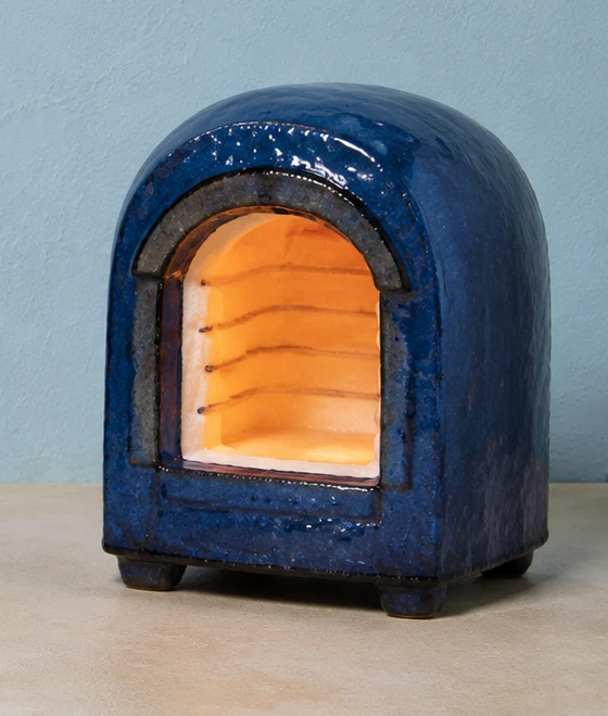 Blue ceramic kiln with a glowing arched chamber